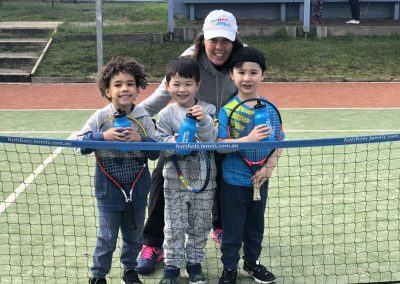 Kids in front of tennis net