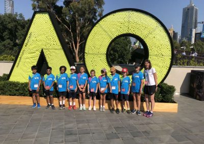 Tennis players in front of AO sign